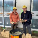 Locatiemanager Anita Rietman en wethouder Arjen van Gijssel leggen de eerste steen van Het Berkelhuis in Eibergen