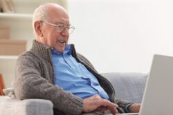 Elderly man using his laptop while at home